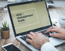 Image of a man at a laptop working on a risk management plan