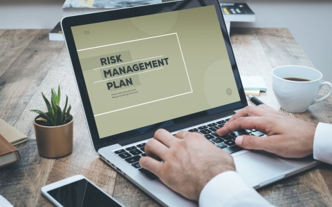 Image of a man at a laptop working on a risk management plan