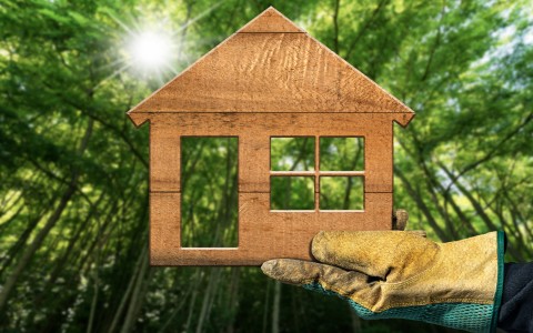 Image of a front profile of a house being held by a gloved hand